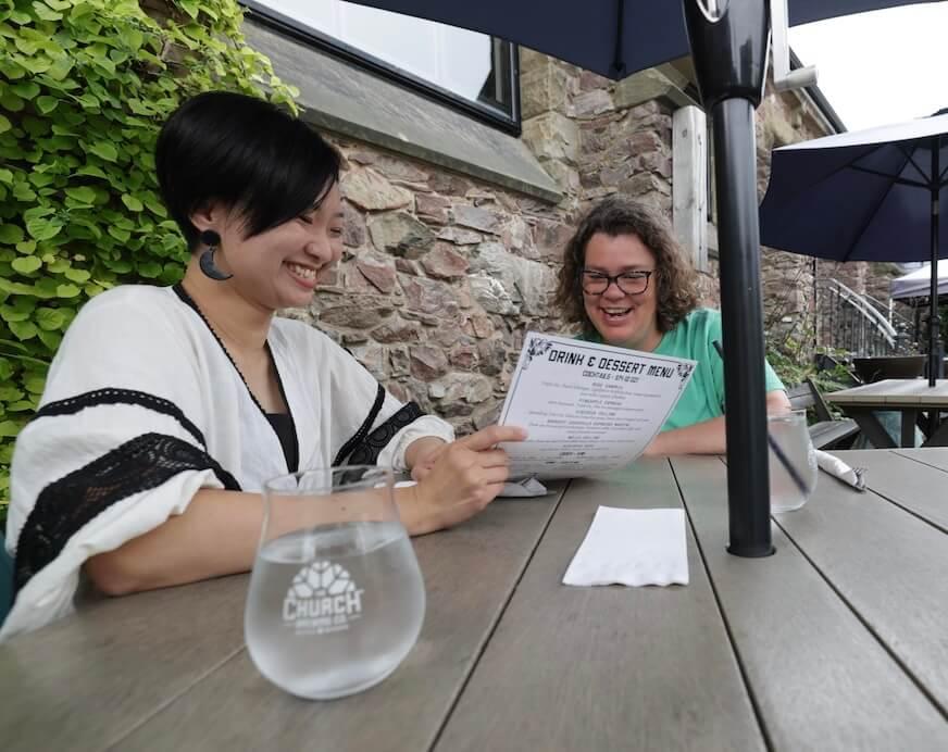 Two people at a restaurant table looking at a menu